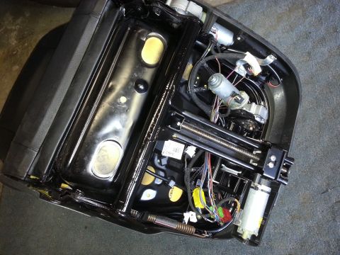 1967 Ford F-100 - Underside of a car seat shows complex electrical and mechanical components.