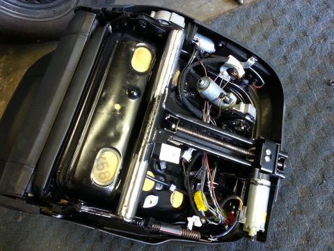 1967 Ford F-100 - Underside of a car seat mechanism, showing intricate wiring and electric motors for adjustment.