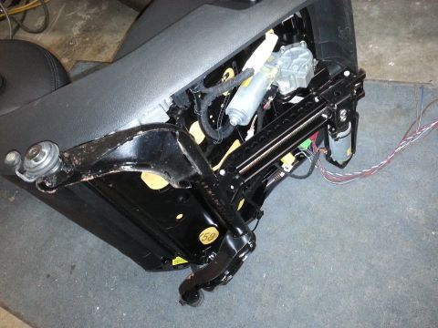 1967 Ford F-100 - Close-up view of a disassembled power seat mechanism, showing motors, rails, and wiring.