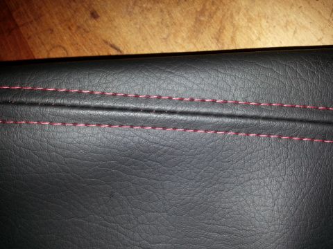 1967 Ford F-100 - Close-up of black leather interior trim with contrasting red stitching.