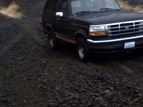 1994 Ford Bronco - This 1994 Ford Bronco is captured in a 3q-front view, navigating a rough, rocky landscape.