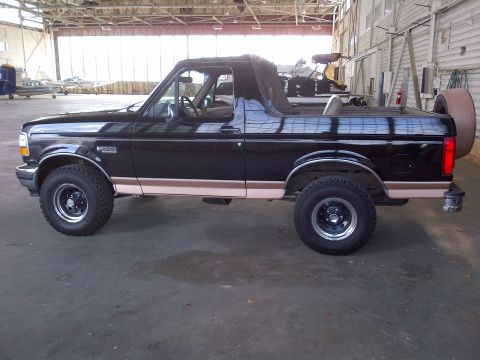 1994 Ford Bronco - This 1994 Ford Bronco is seen from the side, parked indoors with airplanes in the background.
