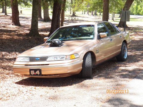 1993 Ford Crown Victoria - A modified 1995 Ford Crown Victoria sits parked in a wooded area.
