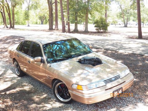 1993 Ford Crown Victoria - Gold 1993 Ford Crown Victoria modified with a hood scoop revealing the engine intake.