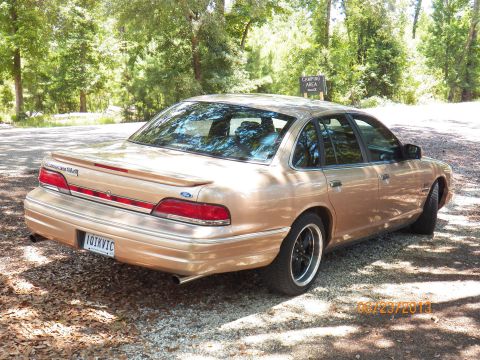 1993 Ford Crown Victoria - A 1993 Ford Crown Victoria is parked in a wooded area with a camping sign visible.