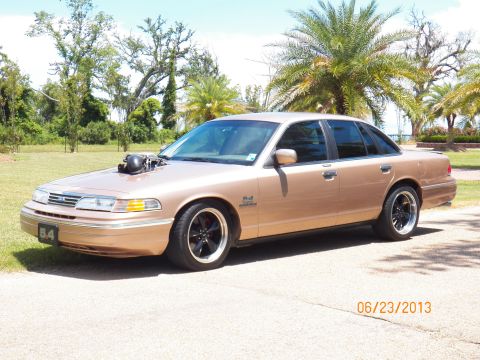 1993 Ford Crown Victoria - Modified 1993 Ford Crown Victoria with a prominent hood scoop and aftermarket wheels.