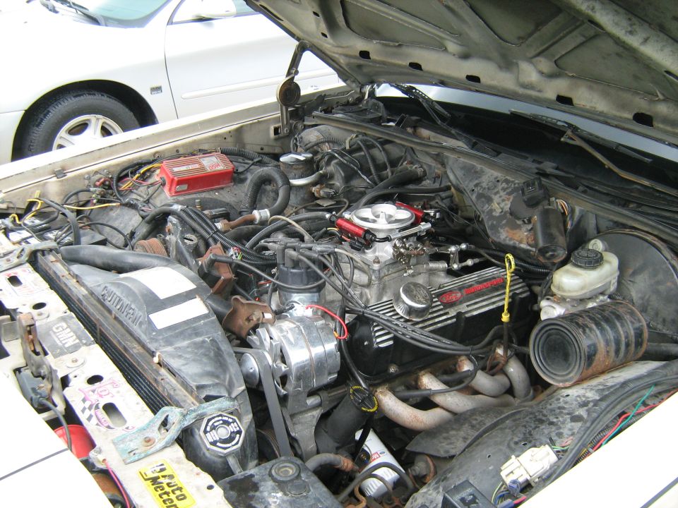 Dirty V8 engine bay with carburetor and aftermarket parts