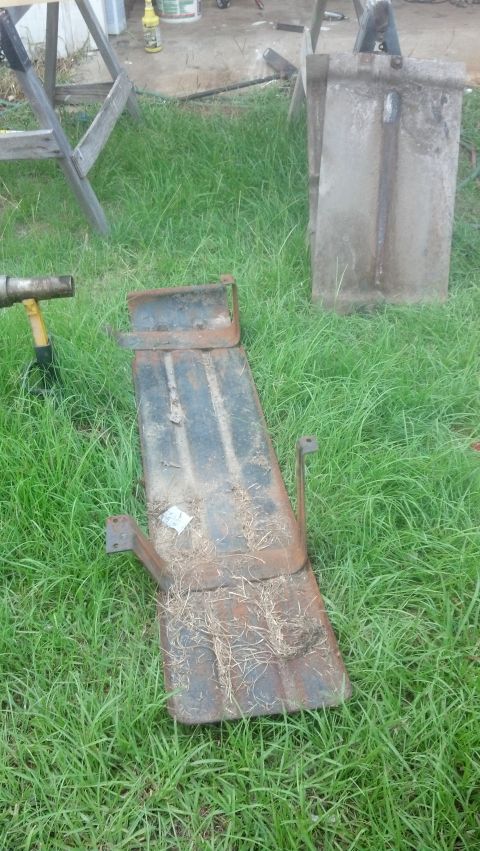 1983 Ford F-250 - A rusted metal part is shown lying on the grass outdoors.