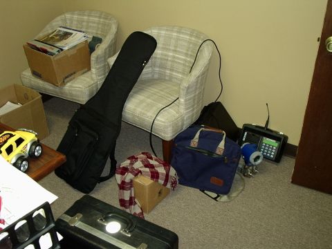 2000 Ford Taurus - Various items are scattered around a room, including a guitar case, bags, and a toy car.