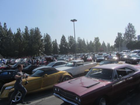 1964 Ford Ranchero - A collection of classic cars fills a parking lot under a clear blue sky.