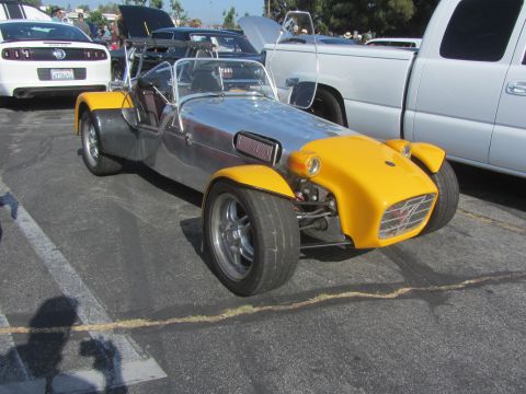 1964 Ford Ranchero - A custom-built sports car with a polished aluminum body and bright yellow fenders is parked outdoors.