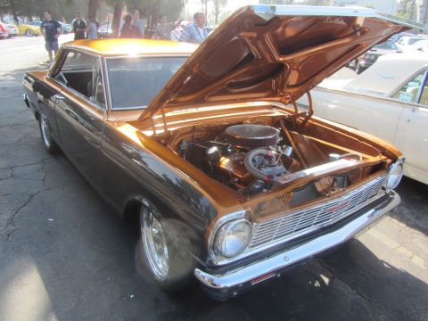 1964 Ford Ranchero - A customized coupe with its hood open, revealing the engine, parked next to another vehicle.