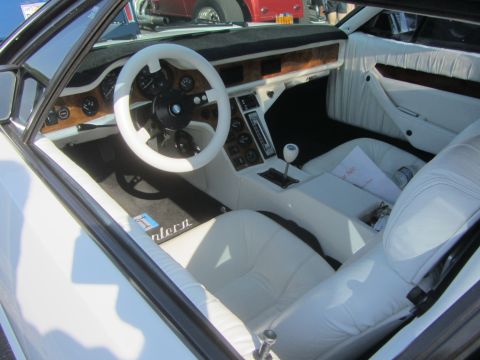 1964 Ford Ranchero - The interior of a car is shown, with white leather seats and a white steering wheel.