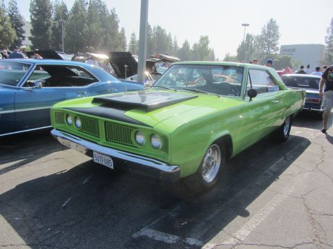 1964 Ford Ranchero - Lime green 1966 Dodge Coronet parked at a car show with other vehicles present.