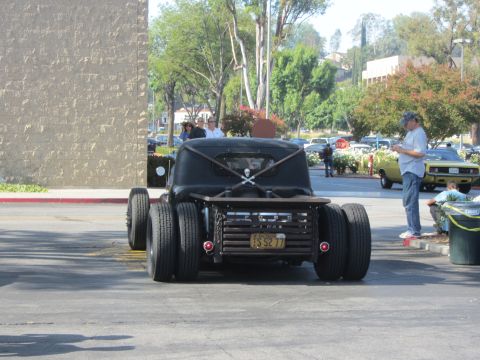 1964 Ford Ranchero - A custom hot rod truck with a unique rear bed design is parked in a lot with other vehicles.