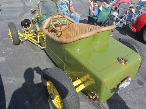 1964 Ford Ranchero - A custom hot rod with a unique green paint job and yellow wire wheels is parked outdoors.