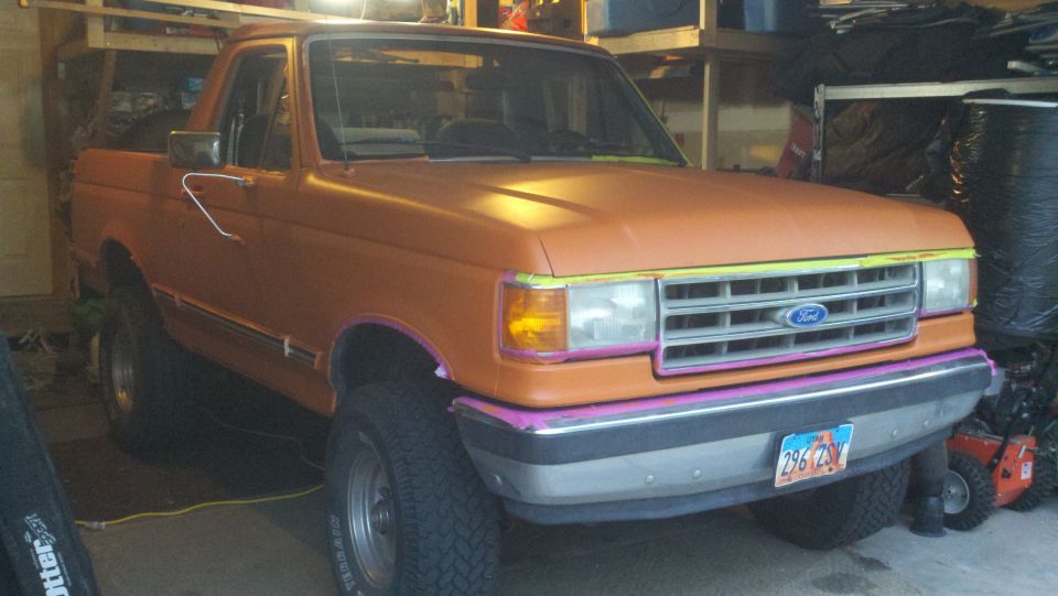 Orange Ford Bronco with custom paint accents on grille and bumper