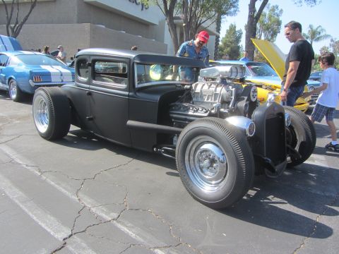 1964 Ford Ranchero - A custom hot rod with a prominent supercharger is displayed at an outdoor car event.