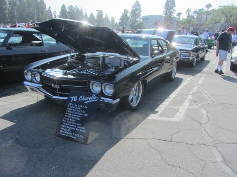 1964 Ford Ranchero - A black 1970 Chevrolet Chevelle SS is displayed with its hood open, showing engine details and a modification sign.