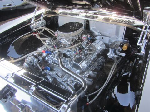 1964 Ford Ranchero - The engine bay of a car is filled with a highly polished V8 engine and custom components.