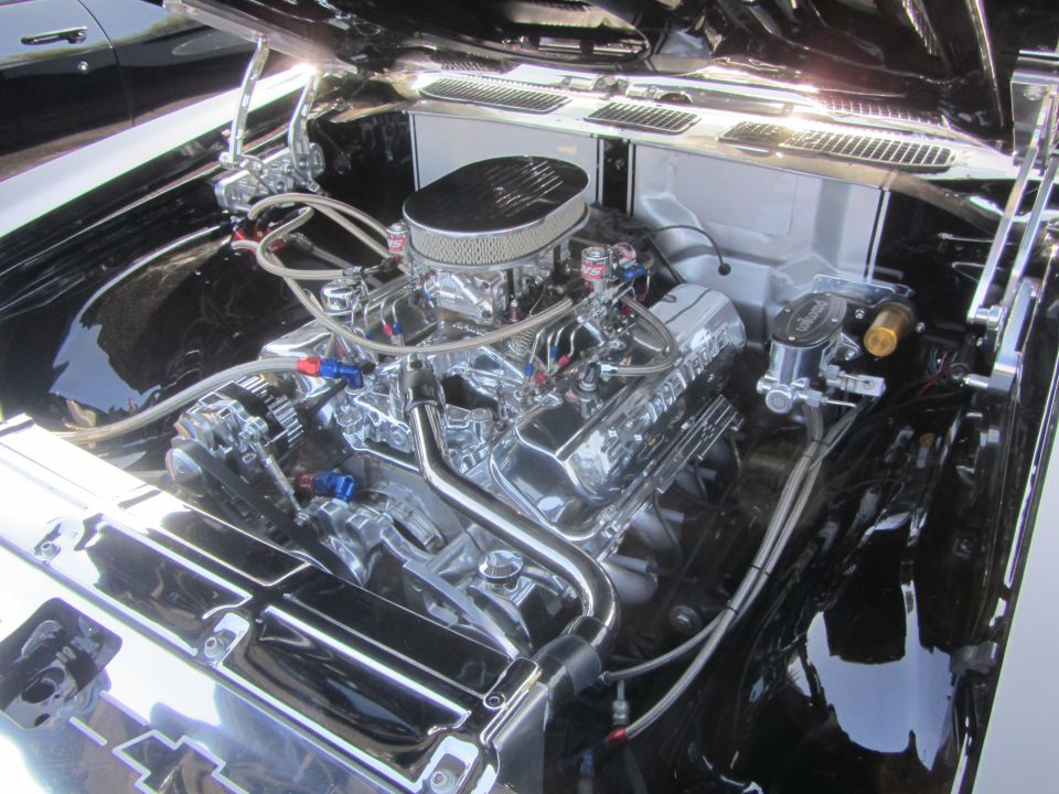 Engine bay with a shiny V8 engine, chrome air cleaner, and braided hoses