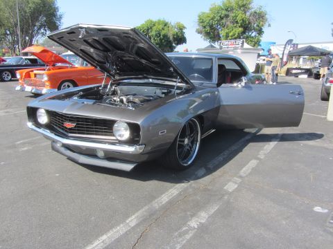 1964 Ford Ranchero - A gray 1969 Chevrolet Camaro is displayed with its hood and driver's door open, revealing the engine bay.