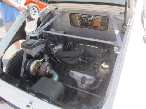 1964 Ford Ranchero - The engine bay of a car is open, revealing a turbocharger and other engine components. The interior is visible through the rear window.