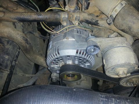 1988 Ford Bronco - Close-up view of engine components, including an alternator and drive belt.