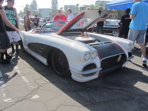 1964 Ford Ranchero - A white 1958 Chevrolet Corvette convertible is displayed with its hood open at an outdoor event.