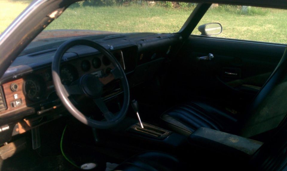 car interior with wood grain dash, steering wheel, and automatic shifter