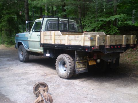 1979 Ford Bronco - This Ford F-Series truck, likely from the early 1970s, features a custom wooden flatbed and a protective rack over the bed.