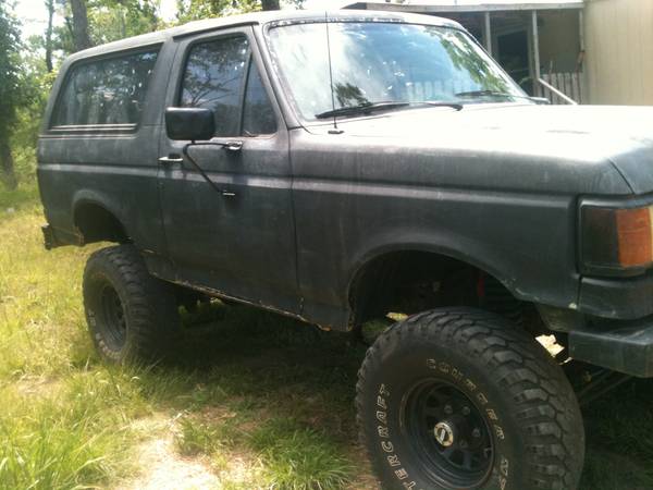 Side view of a dark-colored Ford Bronco with lifted suspension and large tires