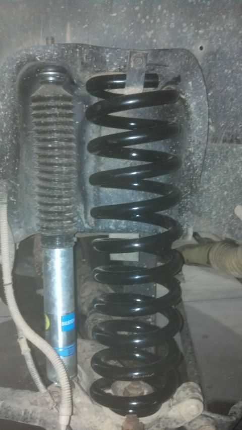 1993 Ford Bronco - Close-up of a vehicle's suspension system, showing a coil spring and a shock absorber.