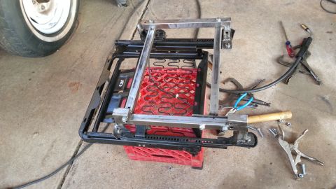 1991 Ford Festiva - A car seat frame is shown disassembled and resting on a red crate, with various tools scattered around.