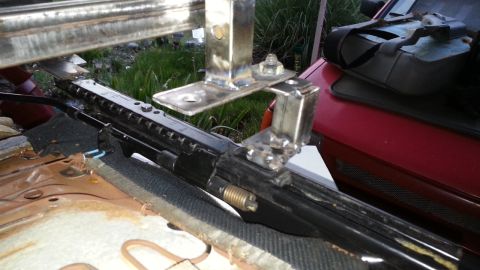 1991 Ford Festiva - Custom metal fabrication is shown attached to a vehicle's seat mounting hardware.