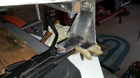 1991 Ford Festiva - Close-up of a metal bracket being worked on, with tools and gloves nearby.