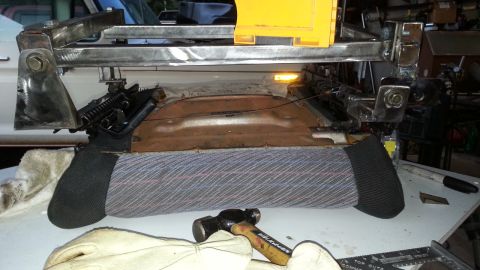 1991 Ford Festiva - Close-up of a car seat frame and its upholstery, with tools nearby, suggesting repair or modification.