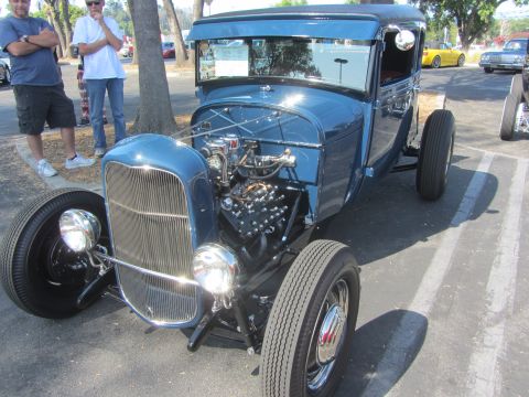 1964 Ford Ranchero - This custom hot rod features an exposed engine and a prominent chrome grille, parked outdoors.