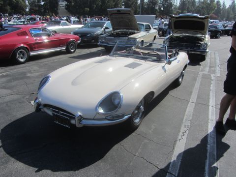 1964 Ford Ranchero - A cream-colored convertible sports car is parked at an outdoor car show with other vehicles.