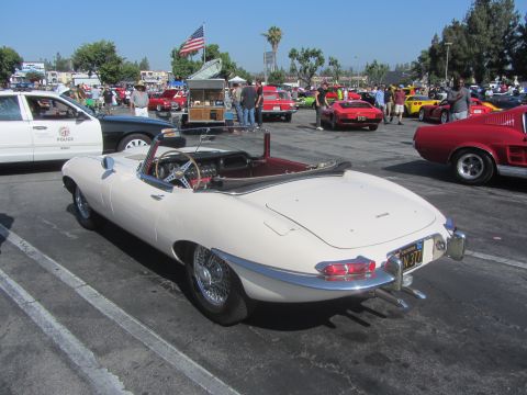 1964 Ford Ranchero - A white Jaguar E-Type convertible is seen from the rear at a car show event.