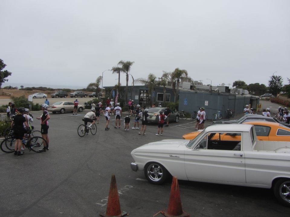 white 1964 Ford Ranchero parked near cyclists