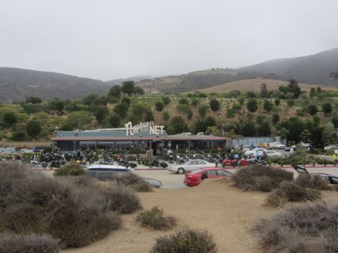 1964 Ford Ranchero - A wide view of Neptune's Net restaurant and its busy parking lot, filled with motorcycles and cars.
