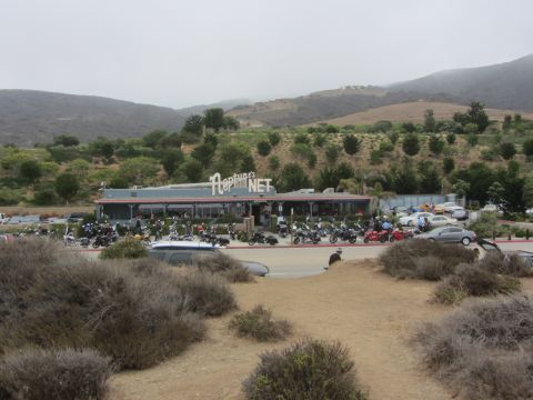 1964 Ford Ranchero - A large gathering of motorcycles fills the parking lot of Neptune's Net restaurant on a cloudy day.