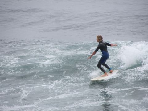 1964 Ford Ranchero - A surfer catches a wave on a cloudy day, their skills on the water.