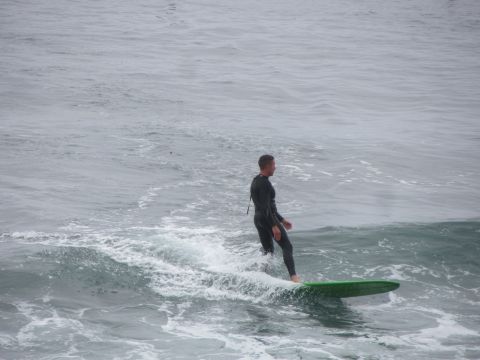 1964 Ford Ranchero - Surfer rides a wave on a green surfboard under an overcast sky.