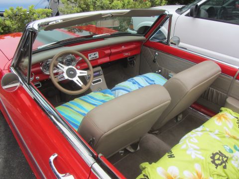 1964 Ford Ranchero - Interior view of a red convertible, possibly a 1963 model, with beach towels covering the seats.
