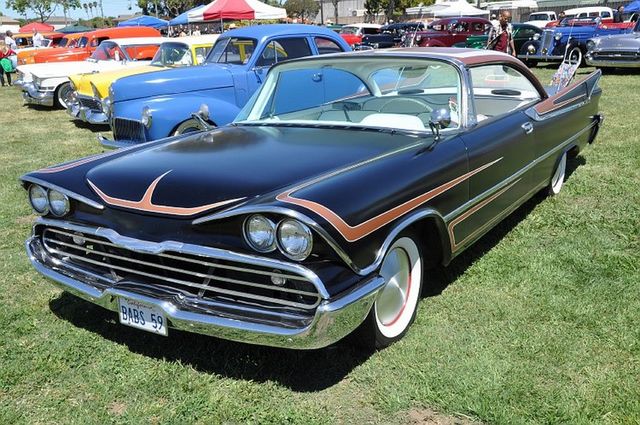 Black 1959 Dodge Custom Royal with copper accents and whitewall tires parked on grass