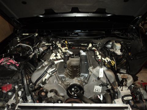 2004 Mercury Grand Marquis - The engine bay of a vehicle is shown with various components and wiring harnesses exposed.
