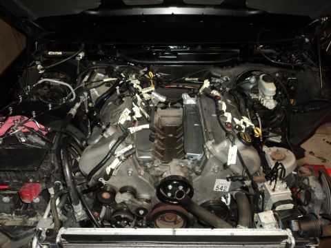 2004 Mercury Grand Marquis - Engine bay with exposed engine and wiring. A part number tag reads 542.