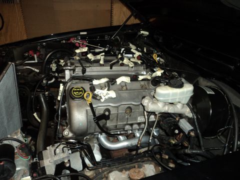 2004 Mercury Grand Marquis - Engine bay with wiring harnesses and brake master cylinder visible.